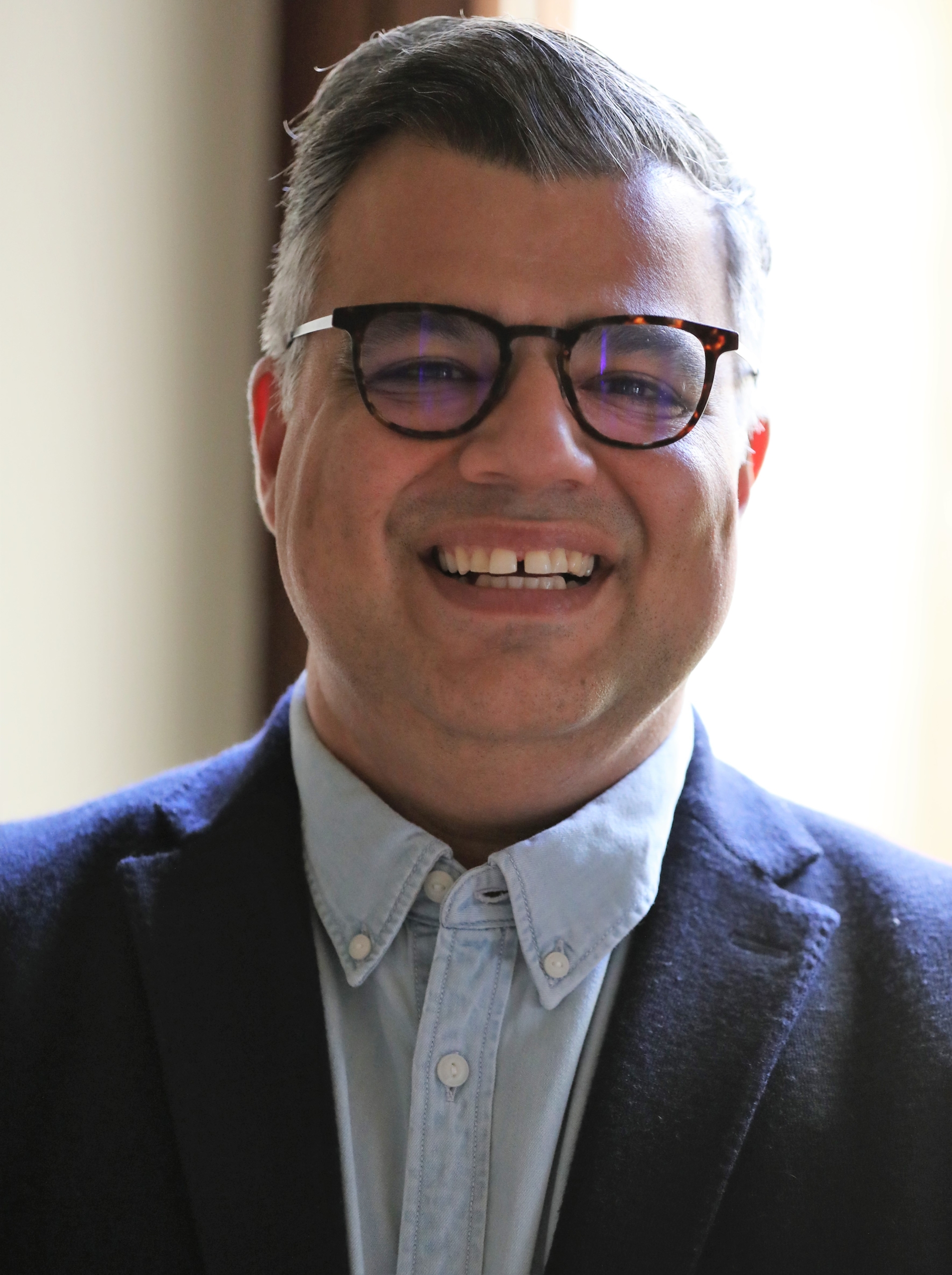 Ali Rezvan, a man wearing glasses and a suit and tie