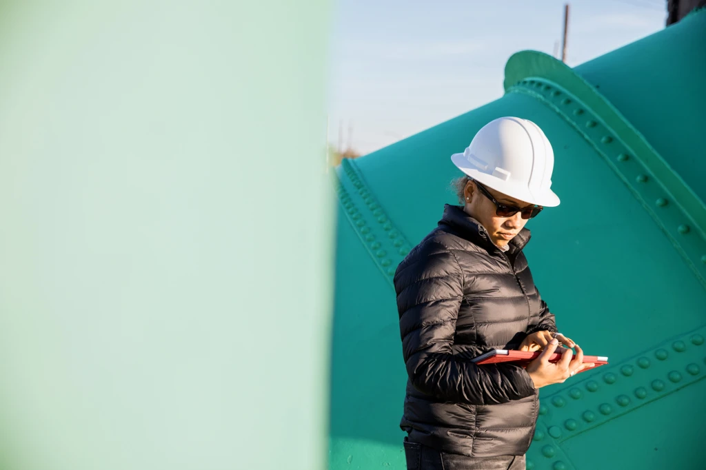 A woman in a hardhat at a water sector treatment plant.