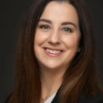 Robin Sutara, a woman with dark brown long hair smiles at the camera