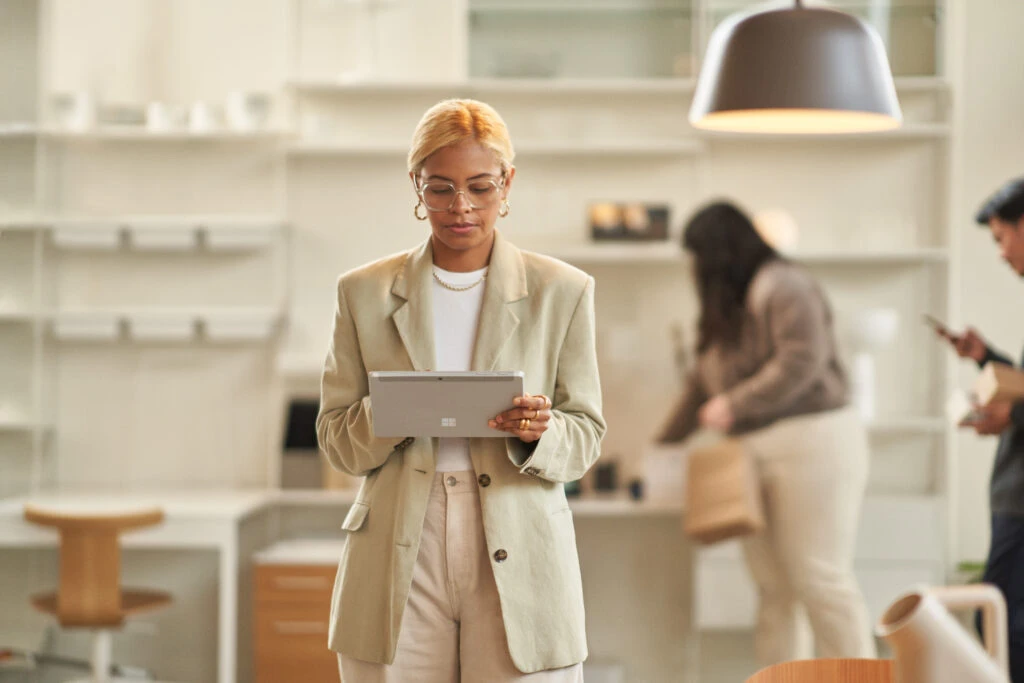 Retail store manager doing queue management via tablet on the store floor. 