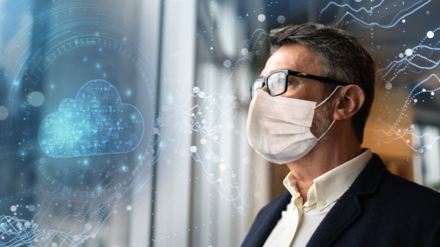 Man with a face mask looking out the window