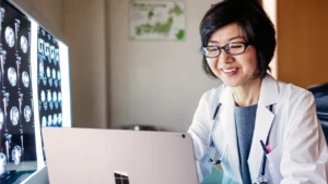 doctor smiling working on her latop