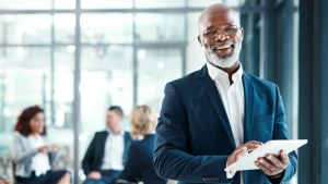 Smiling business man using a tablet.