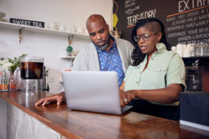 A man and woman looking at a laptop