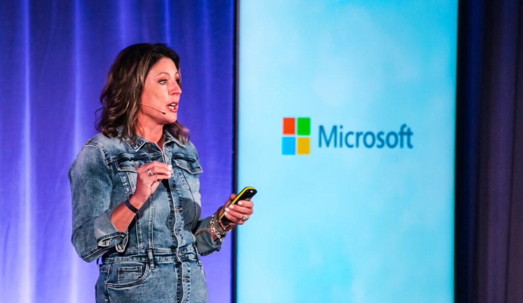 A woman speaking to a large screen