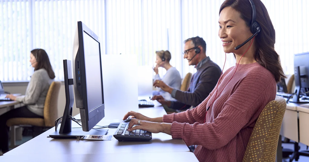 A woman wearing headphones and using a computer