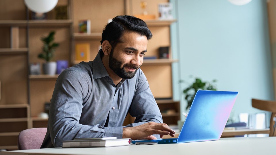 Business decision maker in an office setting working on a laptop with Microsoft scan technology