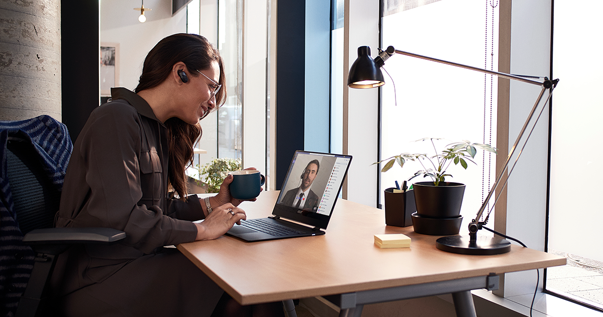 Image of a worker in a Teams conference at her desk.