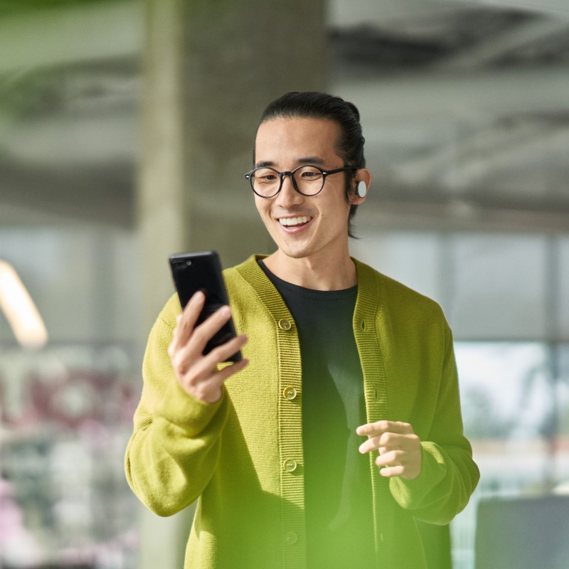A man collaborating with others during a Microsoft Teams meeting while on the go​.