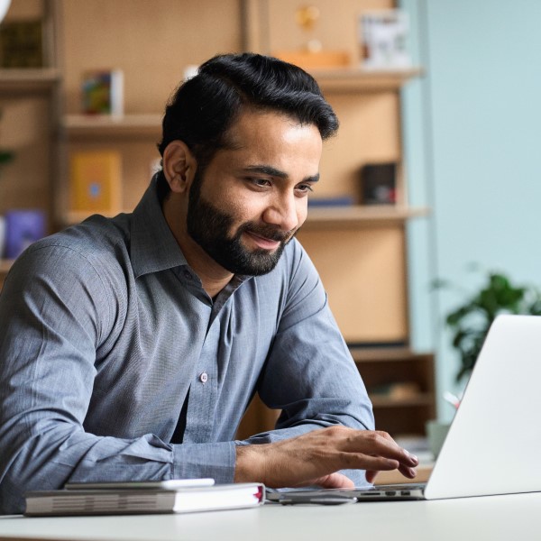 Male professor teaching an online course via a computer in a home office.