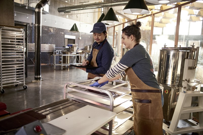 Female/Male small business employees working with Dell XPSv device; stylus.