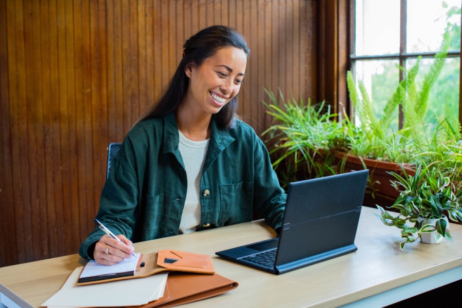 a woman sitting at a table using a laptop computer