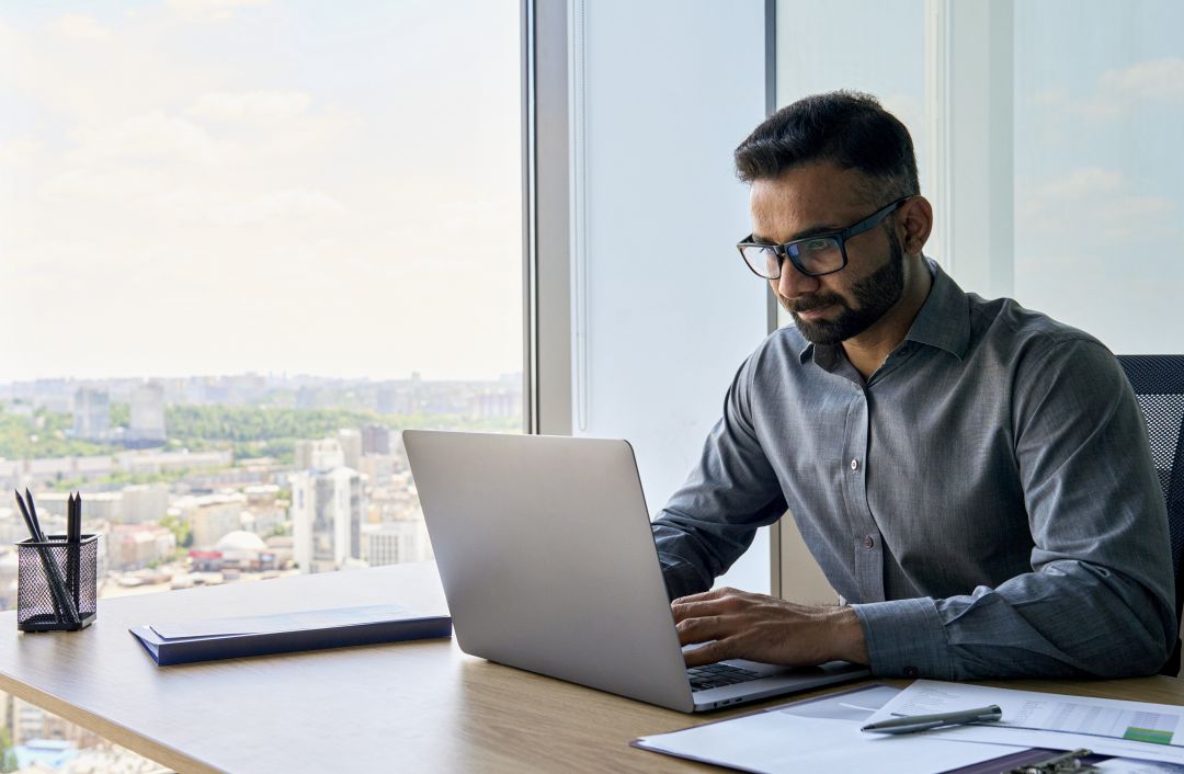 A man sitting at a desk with a laptop