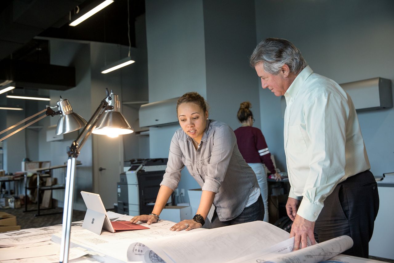 A man and woman looking at a laptop