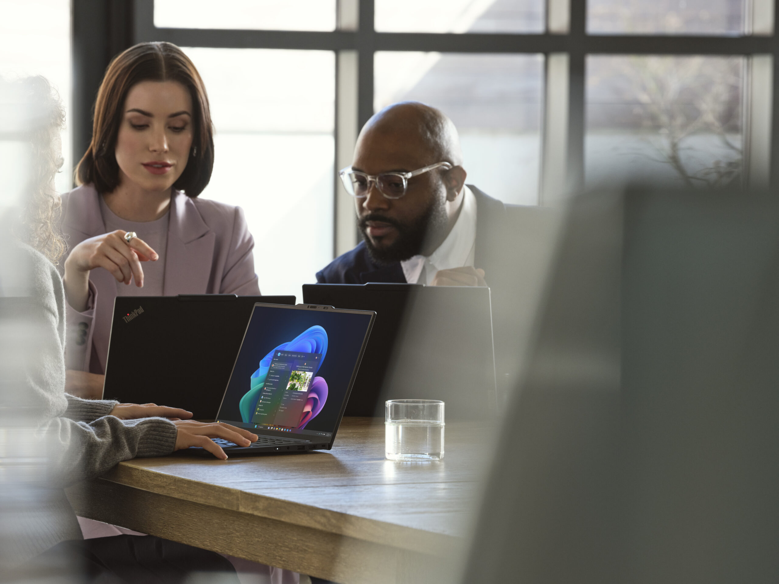A Lenovo device being used by a mixed-gender team in an office space