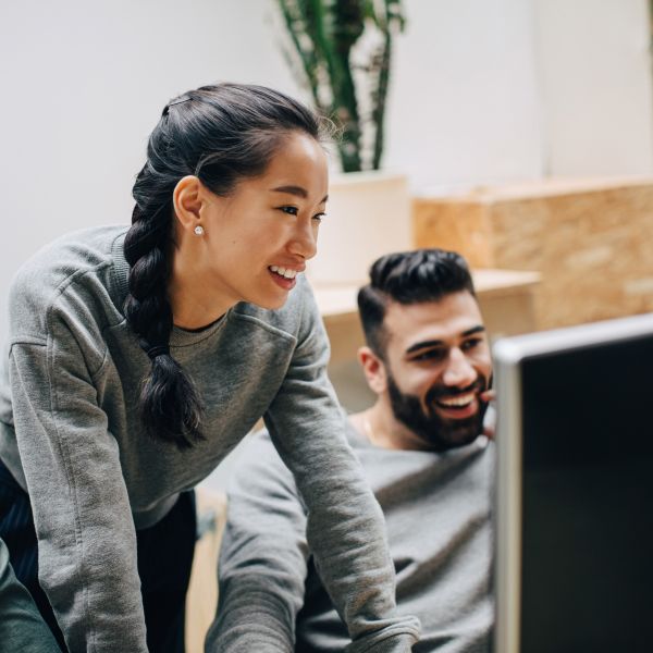 Two people using Microsoft Copilot Studio collaborate in an office setting.