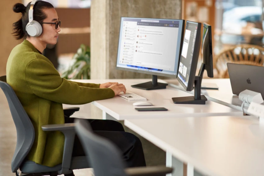 Decorative, a person working on a computer in an office setting. 