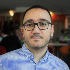 Person in a checkered shirt standing in an indoor setting