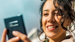 Thumbnail image - A woman smiling while holding a phone