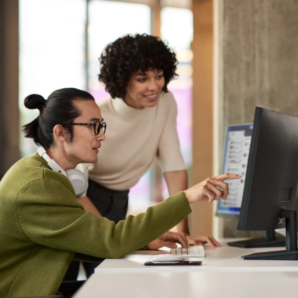 A man and woman looking at a computer screen
