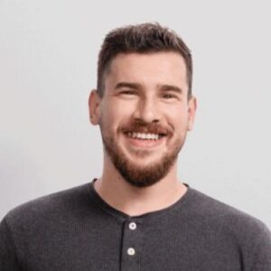 Person wearing a dark gray henley shirt against a plain light gray background