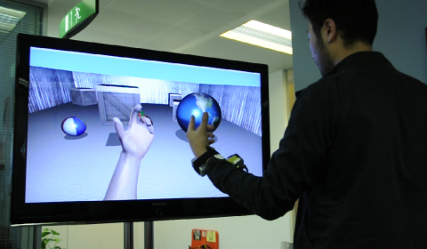 a man standing in front of a flat screen monitor