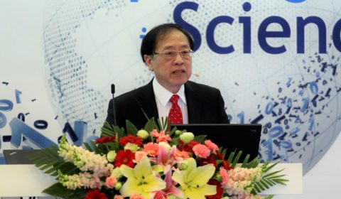 Andrew Yao standing in front of a flower