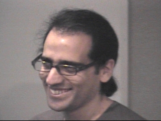 a man wearing glasses and smiling at the camera