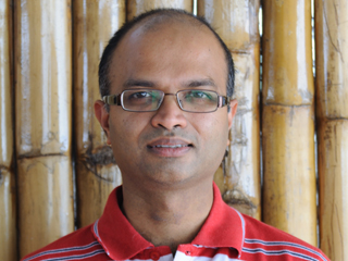 Sriram Rajamani wearing glasses and smiling at the camera
