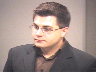 a man wearing glasses and looking at the camera