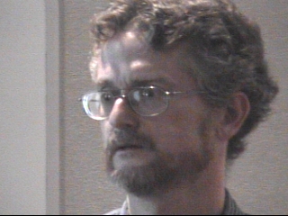 a man wearing glasses and looking at the camera