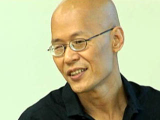 a man wearing glasses and smiling at the camera