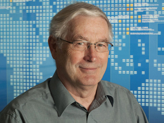 Tony Hey wearing glasses and smiling at the camera