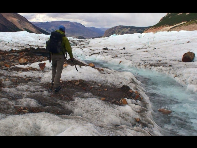 a man riding a snowboard down a snow covered mountain