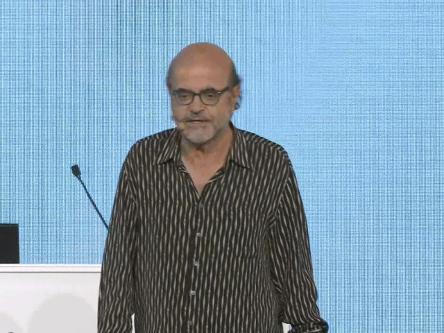 Christos Papadimitriou standing in front of a curtain