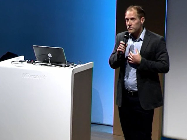 a man in a suit standing in front of a computer