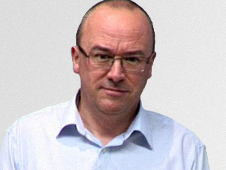 Christopher Bishop wearing glasses and smiling at the camera