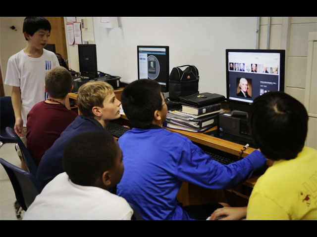 a group of people looking at a computer screen