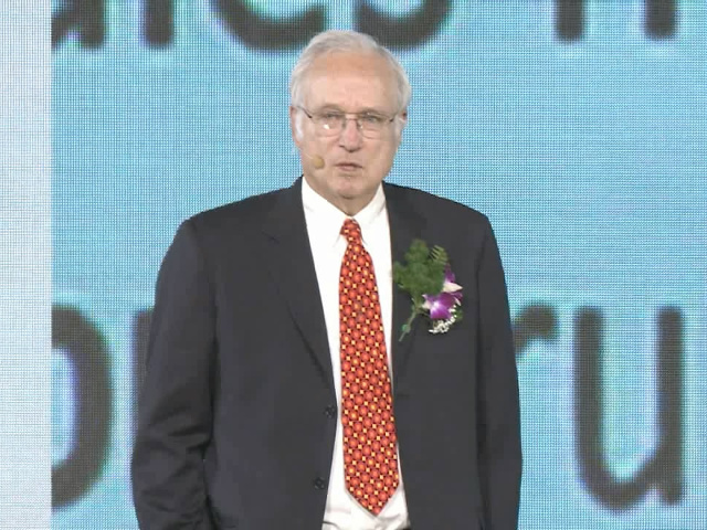 Butler Lampson wearing a suit and tie standing in front of a building