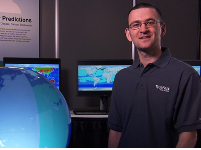 a man standing in front of a monitor