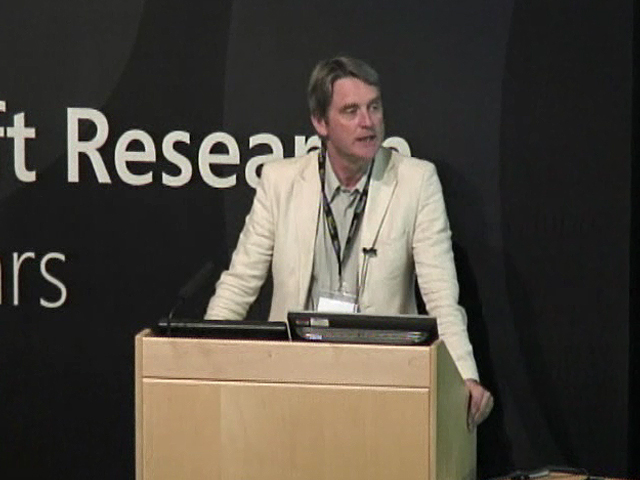 George Barna in a suit standing in front of a box