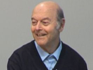 Yuri Gurevich wearing a suit and tie smiling at the camera