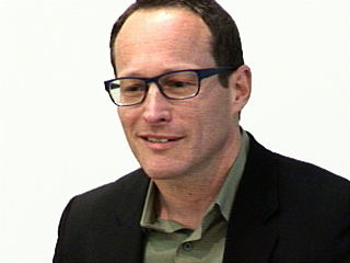 John Krakauer wearing glasses and smiling at the camera