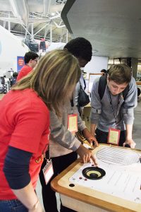 a group of people standing around a table