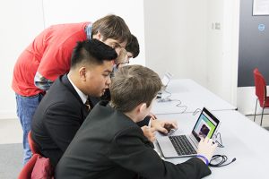 a group of people looking at a laptop