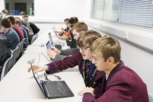 a group of people looking at a laptop