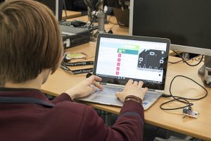 a group of people sitting at a desk in front of a laptop computer