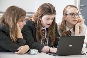 a group of people looking at a laptop