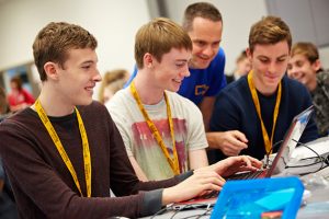 a group of people looking at a laptop
