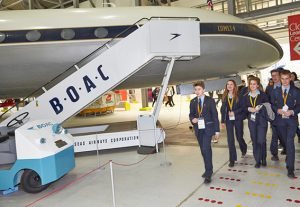 a group of people standing around a plane